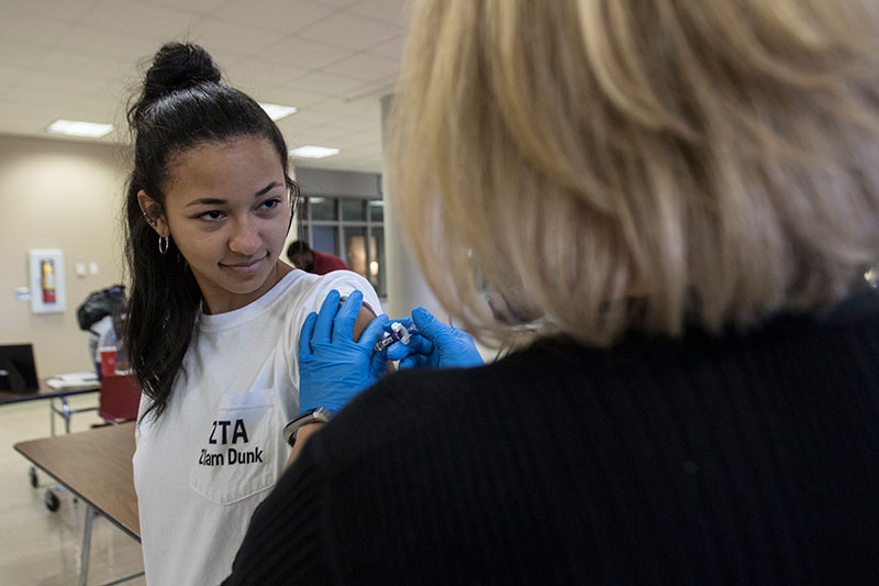 student receiving flu vaccine calmly