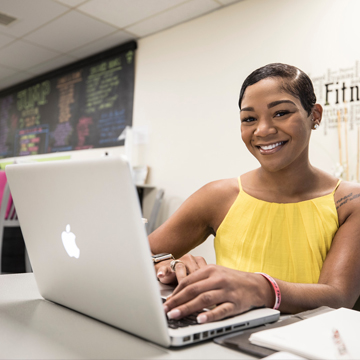 woman smiling and looking up from computer