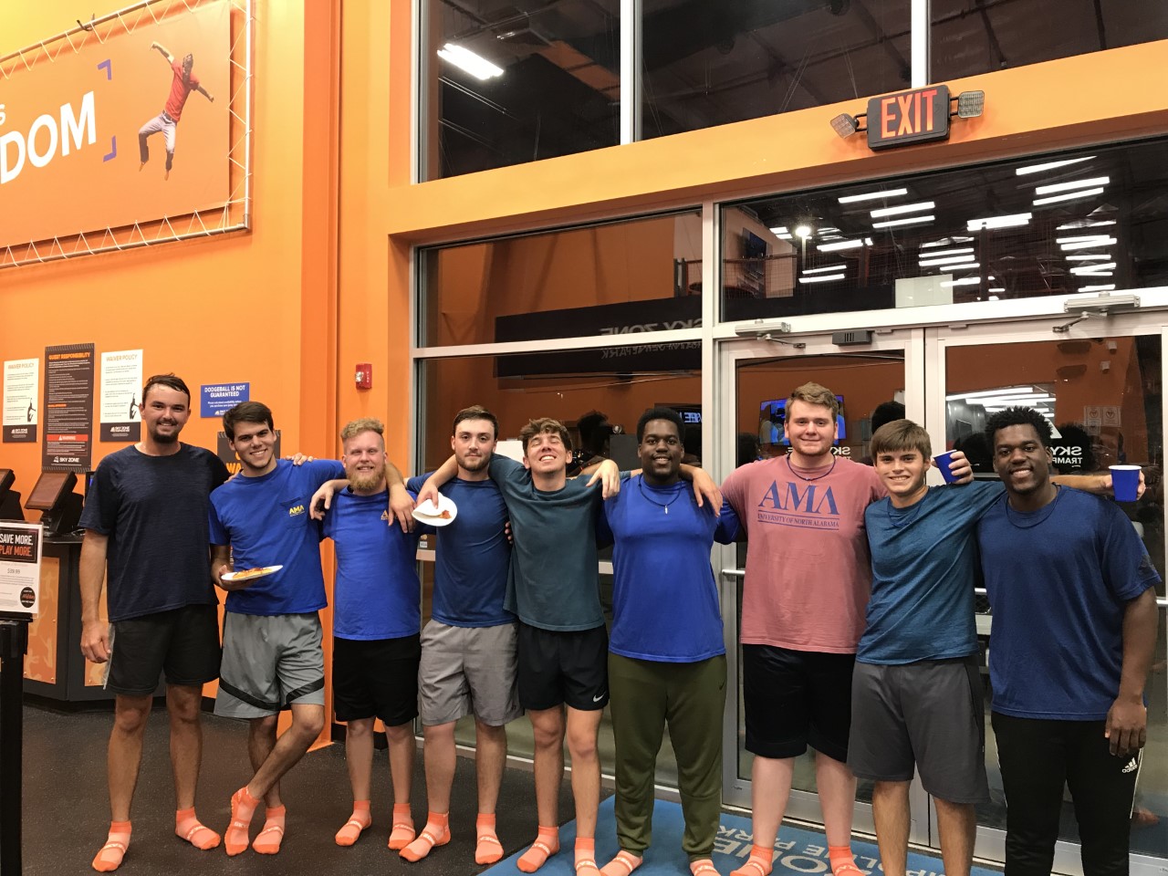 Members of AML smile together at SkyZone. 
